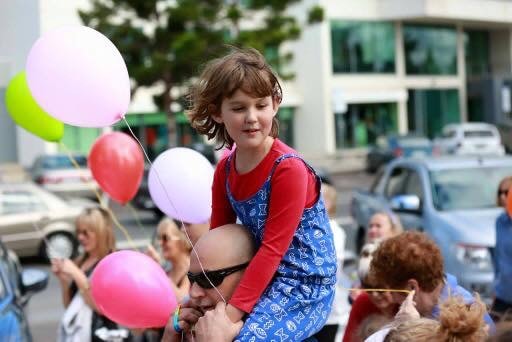 Child with balloons at a community celebration event